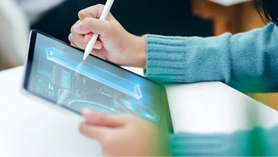 Une personne interagit avec une tablette, en utilisant un stylet pour dessiner un diagramme technique.